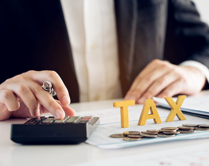 Calculating taxes with coins and calculator.