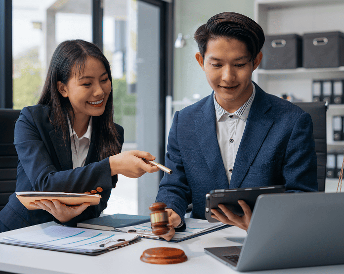 Two professionals discussing legal documents at office table.