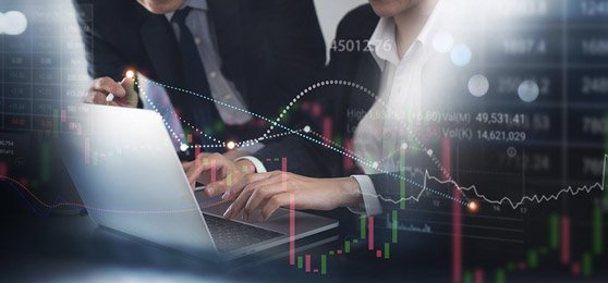 Business meeting with laptop and financial charts.