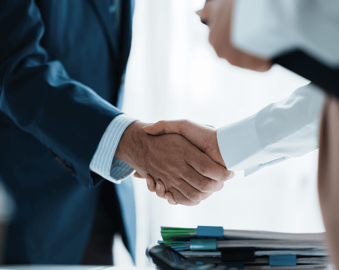 Business handshake between two professionals in suits.