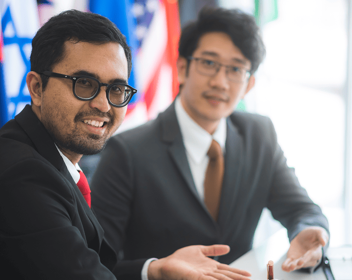 Two businessmen in a meeting with flags background.