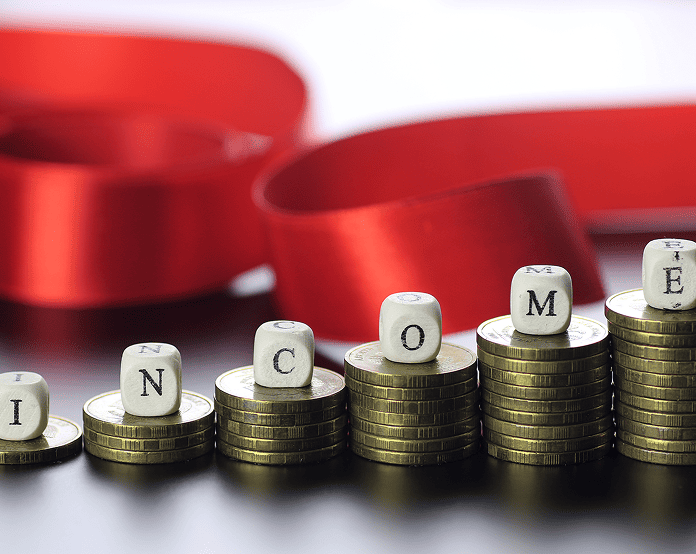 Coins stacked with income dice and red ribbon.