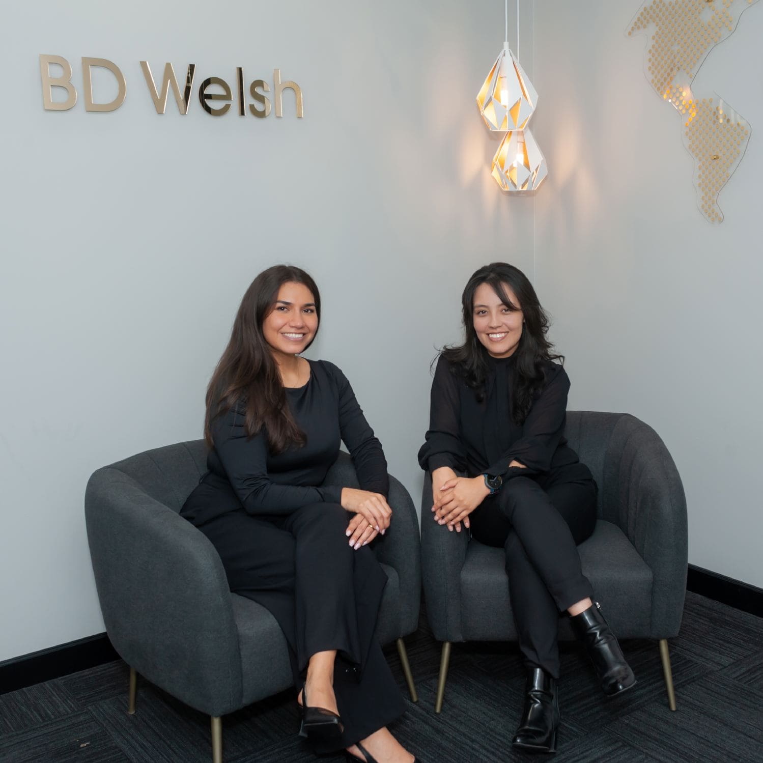Two women seated in modern office lobby