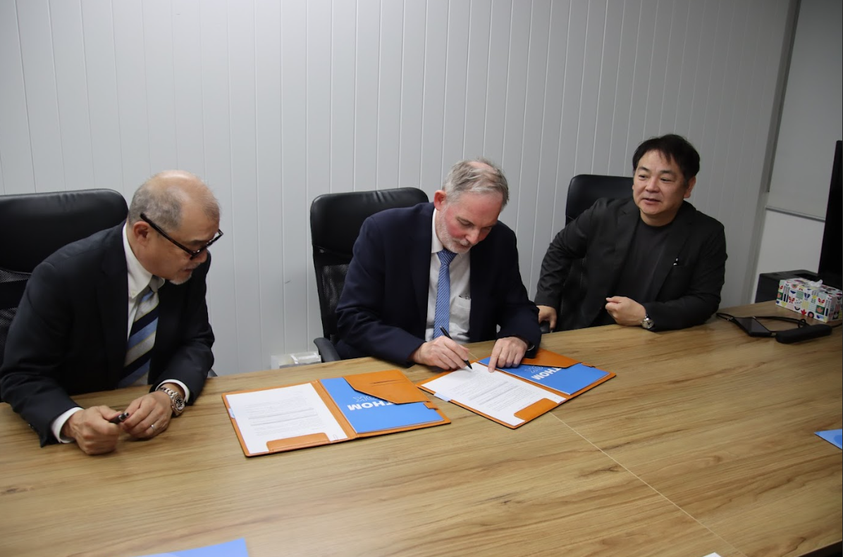 Businessmen signing agreement at conference table