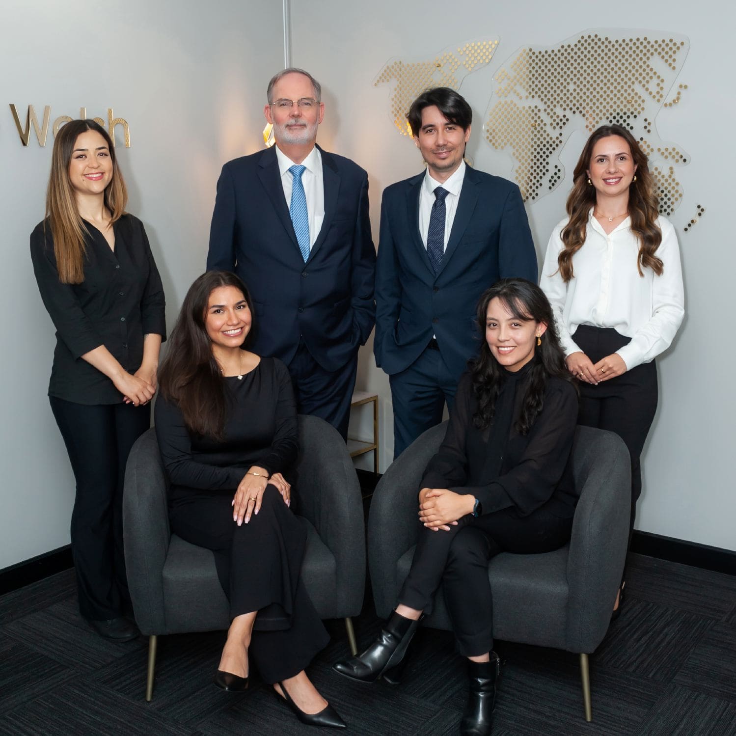 Six business professionals posing in modern office